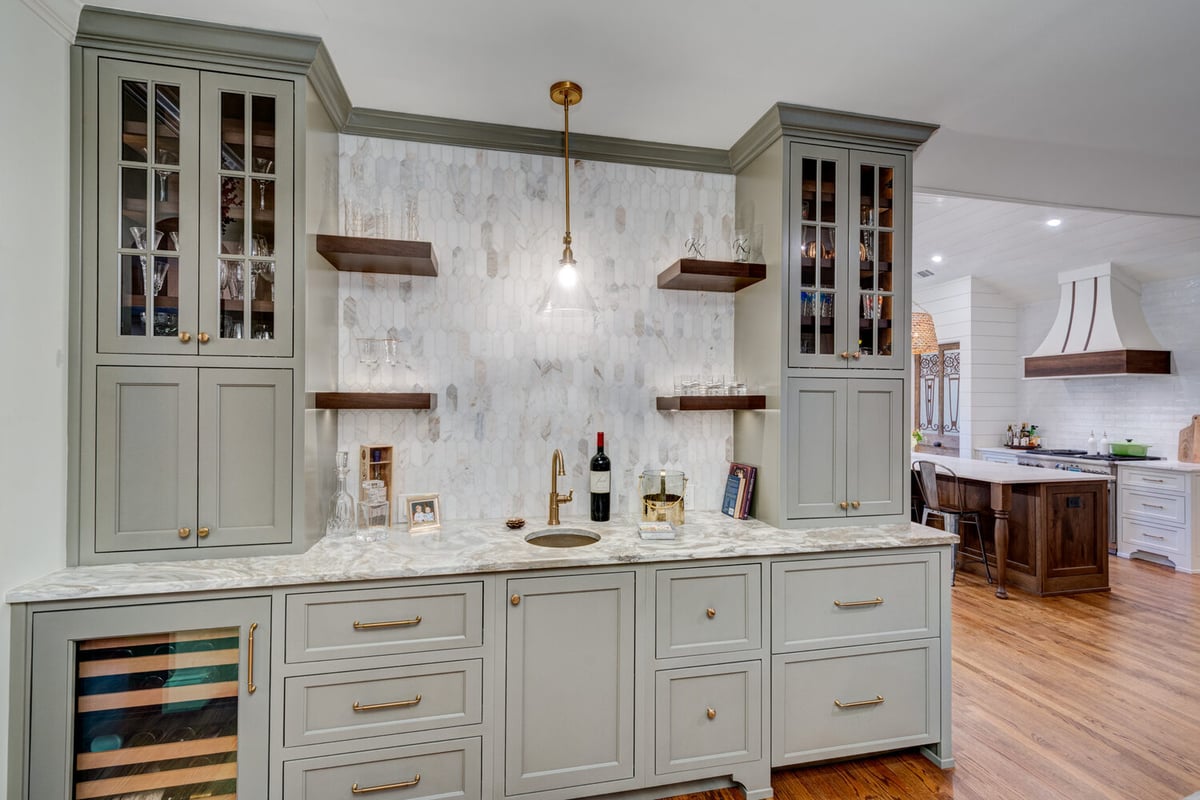 Built-in bar area with marble countertop and glass cabinets by Silver Oak in Roswell, GA