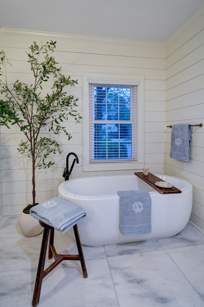 Freestanding soaking tub with shiplap walls and spa-style decor by Silver Oak in Roswell, GA