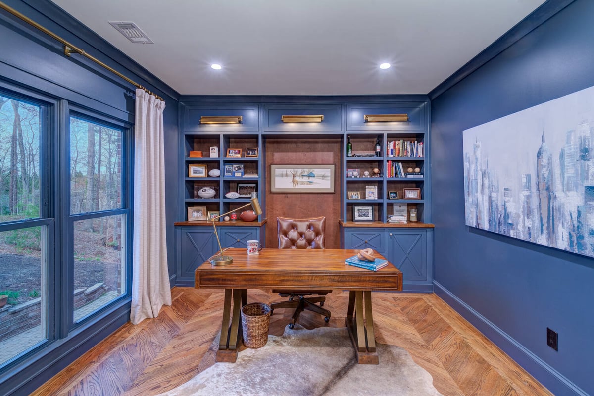 Home office with built-in shelving and blue accent walls remodeled by Silver Oak in Roswell, GA