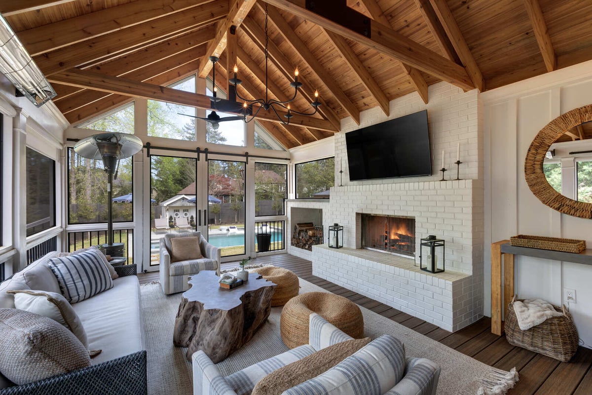 Interior view of East Cobb GA porch addition by Silver Oak Remodel with white brick fireplace and wood ceiling