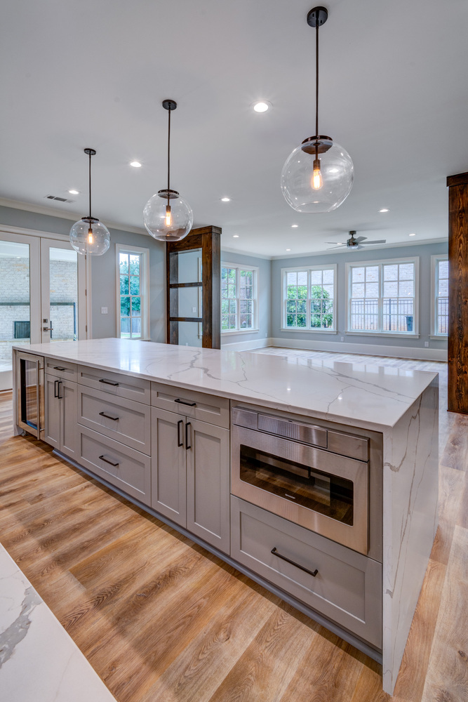 Large kitchen island with stainless appliances in basement remodel by Silver Oak Remodel in Greater Atlanta