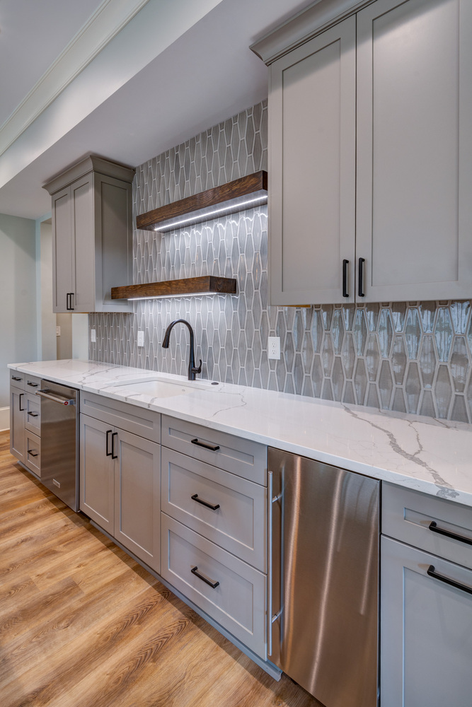 Modern grey cabinetry and floating shelves in Greater Atlanta basement kitchen by Silver Oak Remodel