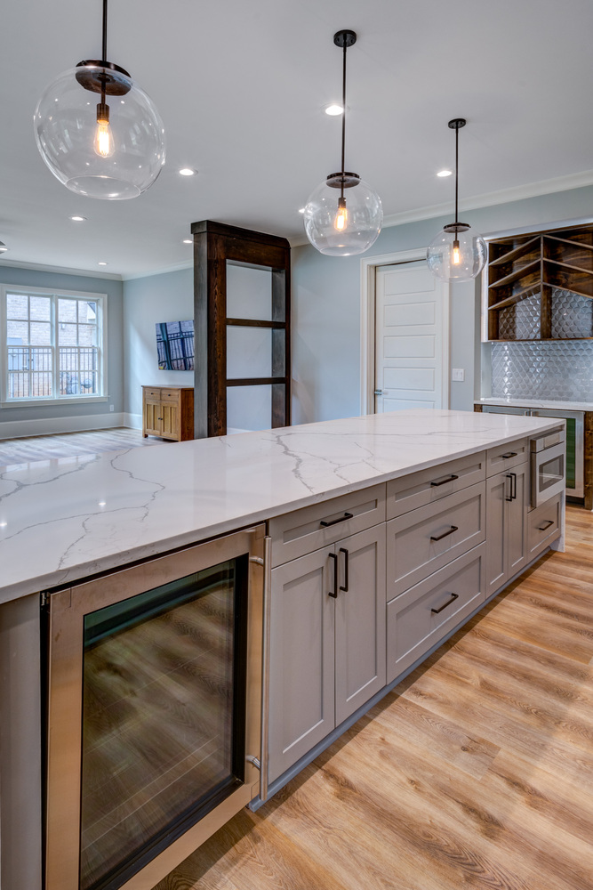 Spacious kitchen island with integrated wine fridge in Greater Atlanta basement remodel by Silver Oak Remodel