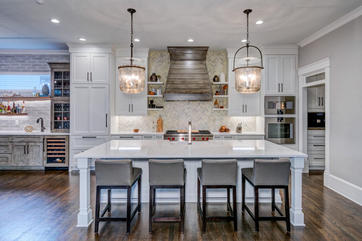 Elegant kitchen remodel with large island, shiplap hood vent, and herringbone backsplash by Silver Oak Remodel in Greater Atlanta