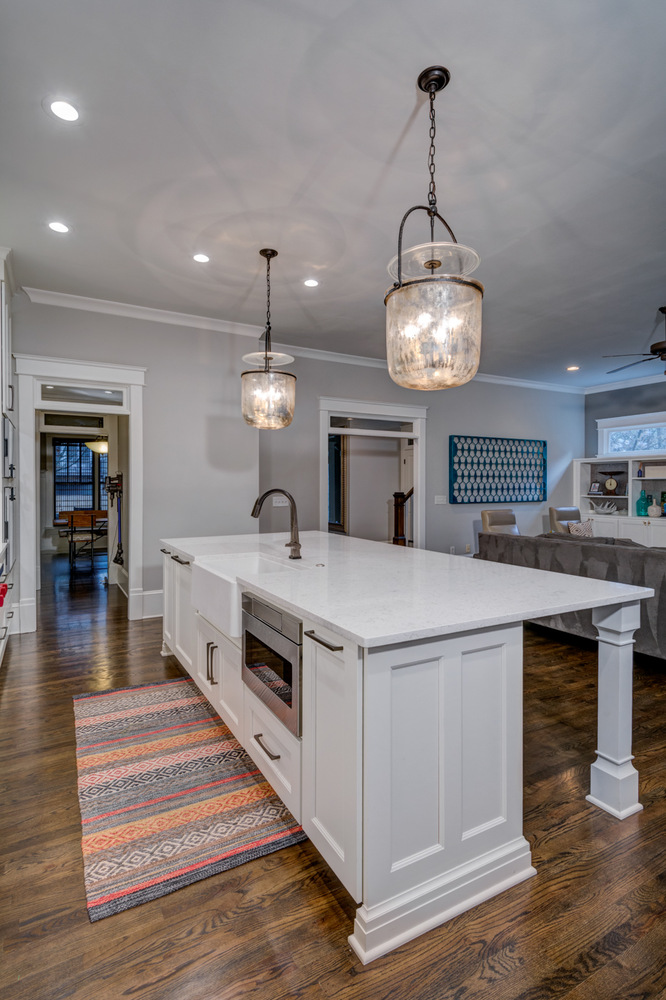 Kitchen island with farmhouse sink and pendant lighting in a modern Greater Atlanta remodel by Silver Oak Remodel