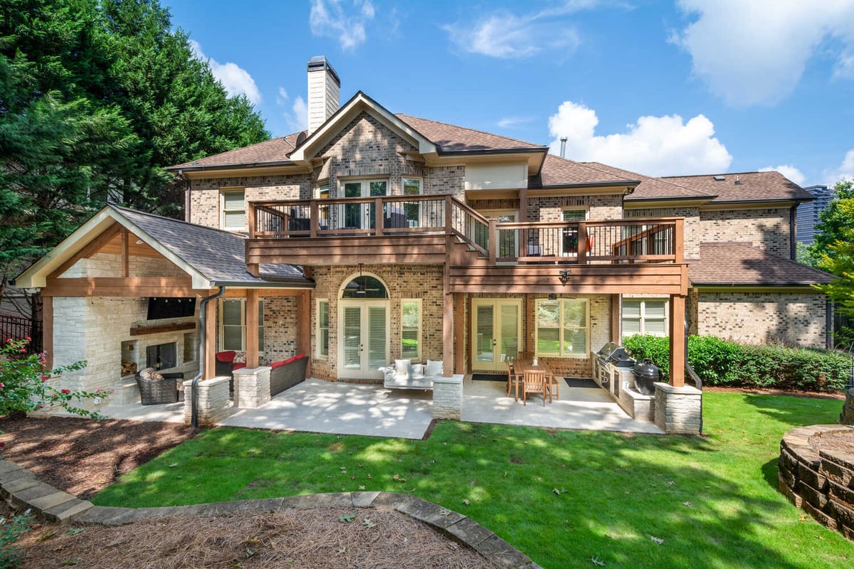 Rear view of custom brick home with expansive dual-level deck by Silver Oak Remodel in Atlanta, GA