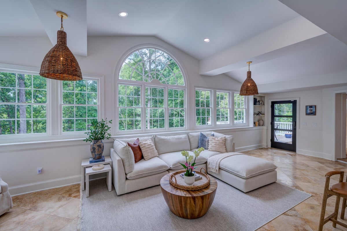 Bright sunroom remodel with arched window and neutral sectional by Silver Oak Remodel in Greater Atlanta