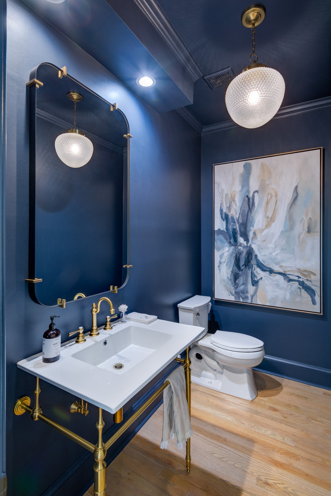 Moody powder room remodel with navy walls and gold fixtures by Silver Oak Remodel in Greater Atlanta