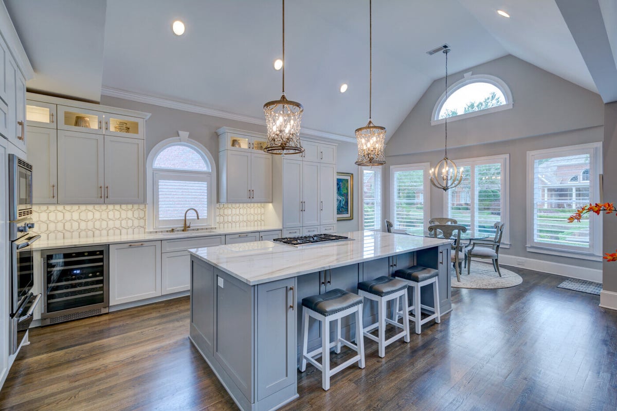 Elegant white and gray kitchen remodel by Silver Oak Remodel in Sandy Springs, GA with vaulted ceiling and island seating
