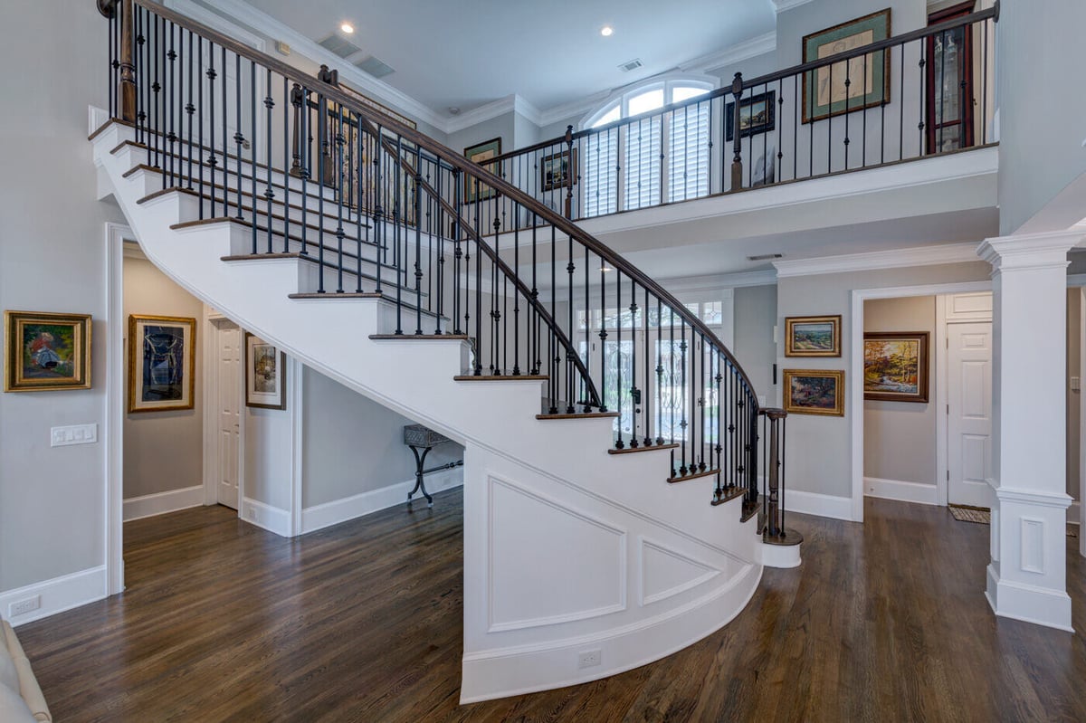 Grand curved staircase with iron railing in Sandy Springs, GA home remodel by Silver Oak Remodel