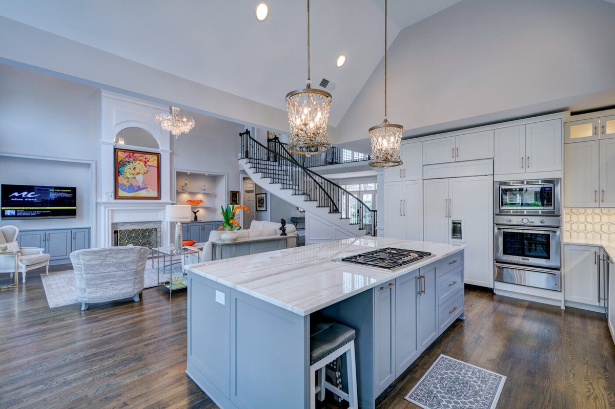 Open-concept kitchen and living area with island and fireplace by Silver Oak Remodel in Sandy Springs, GA