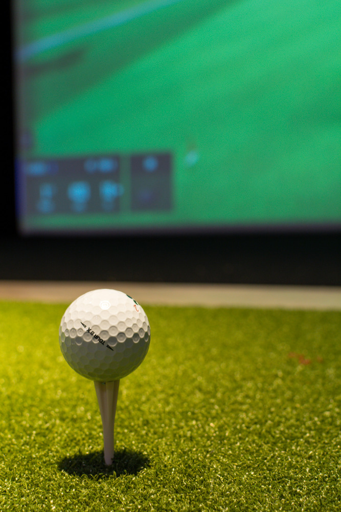Close-up of golf ball on tee inside a high-end simulator room by Silver Oak Remodel in Greater Atlanta