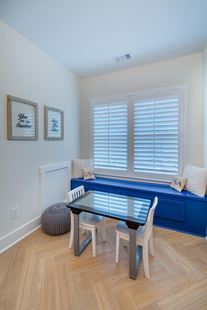 Cozy built-in window bench with white shutters and blue accents by Silver Oak Remodel in Greater Atlanta