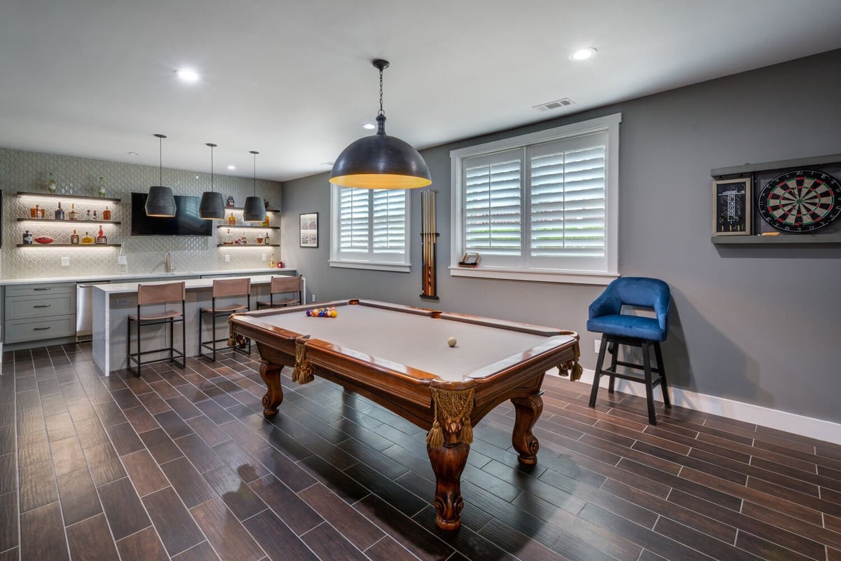 Game room with pool table, bar area, and dart board by Silver Oak Remodel in Greater Atlanta